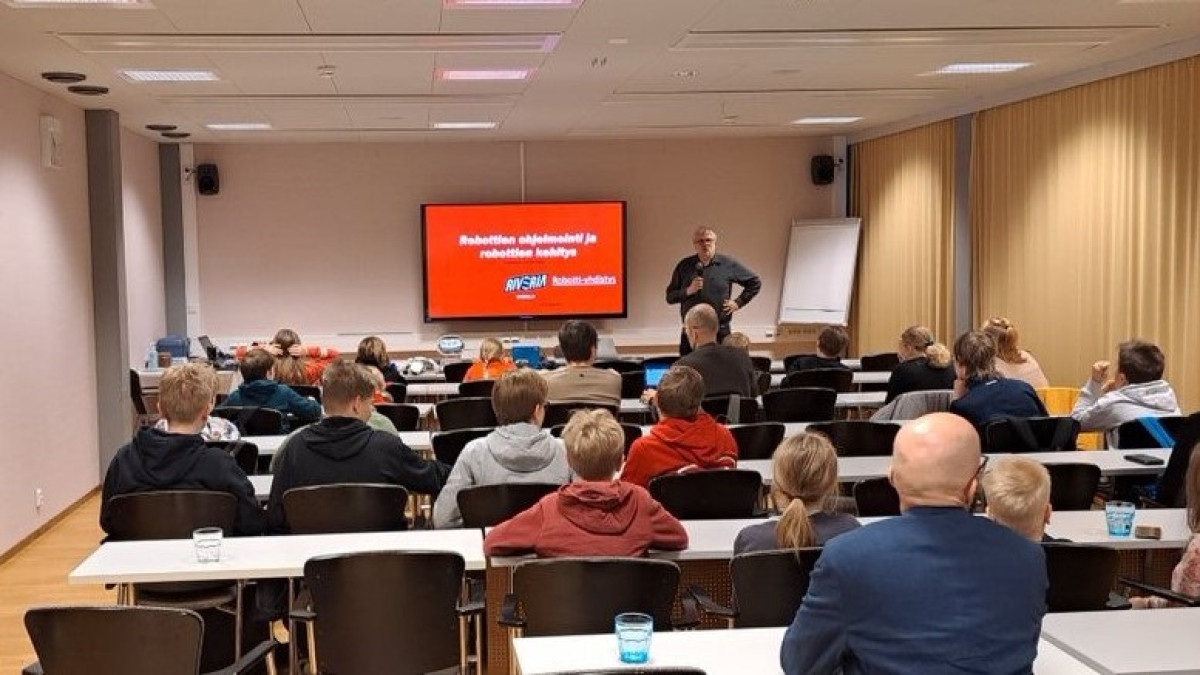 Seminaari, jossa oppilaat istumassa selin kameraan.