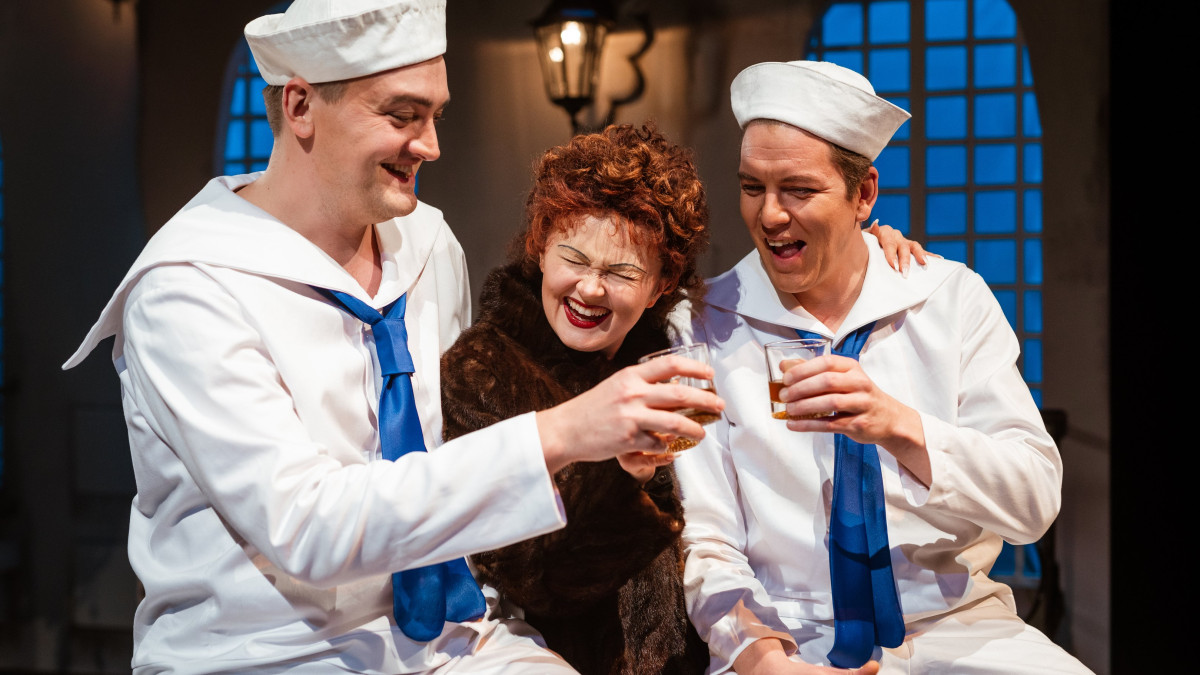 Kolme näyttelijää teatterin lavalla.