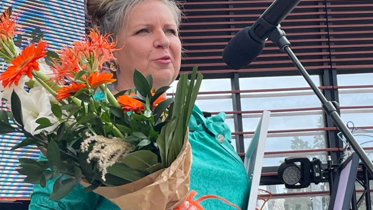 Tiina palkintokukat kädessään pitää kiitospuhetta.