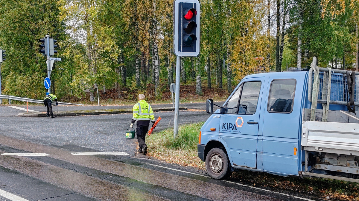 Kiinteistö- ja aluepalvelun työntekijä asentaa aurauskeppejä syksyisessä säässä.