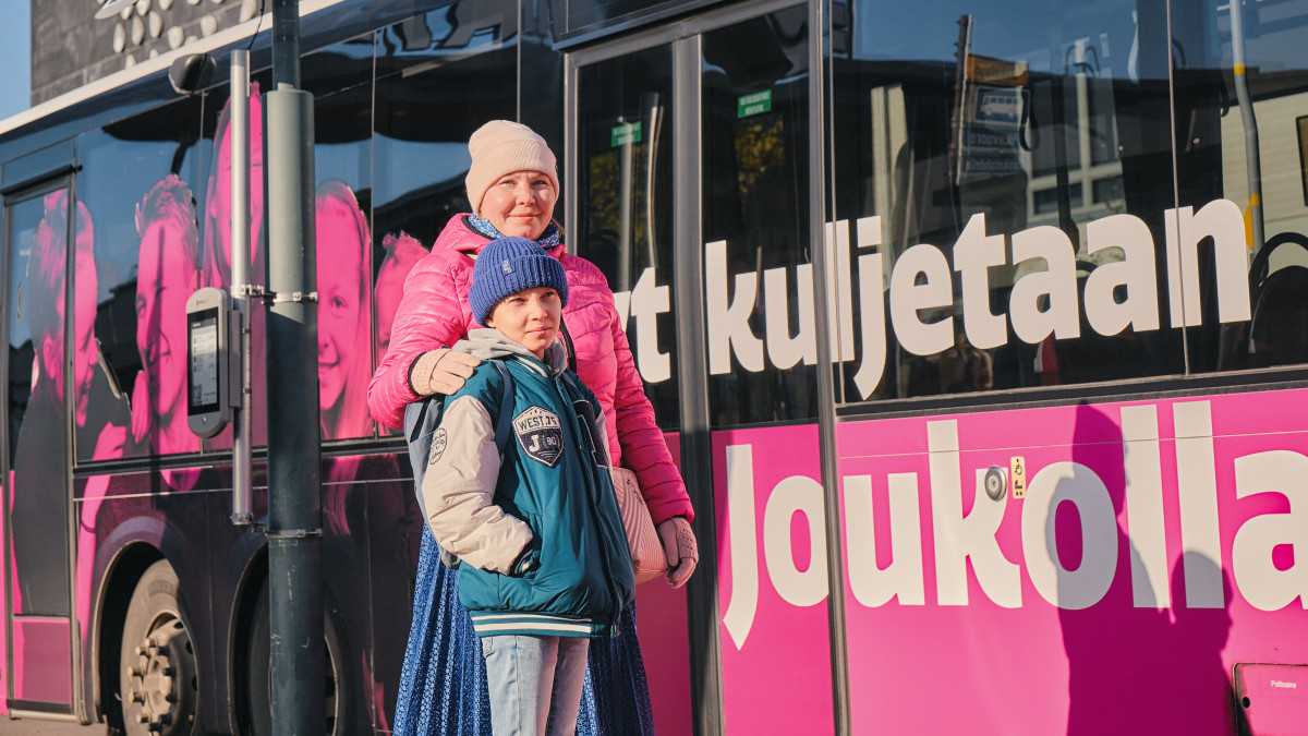 Matkustaijia linja-auton vieressä.