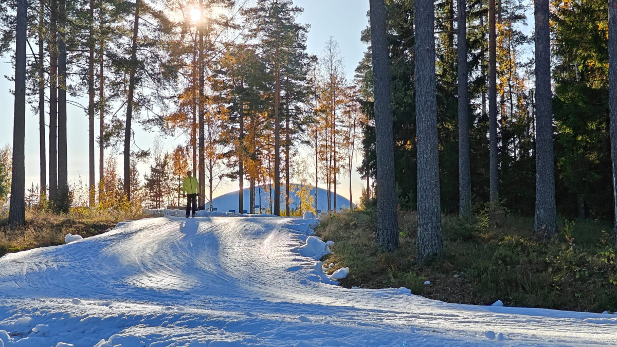 Hiihtäjä ensilumenladulla. Sää on aurinkoinen.