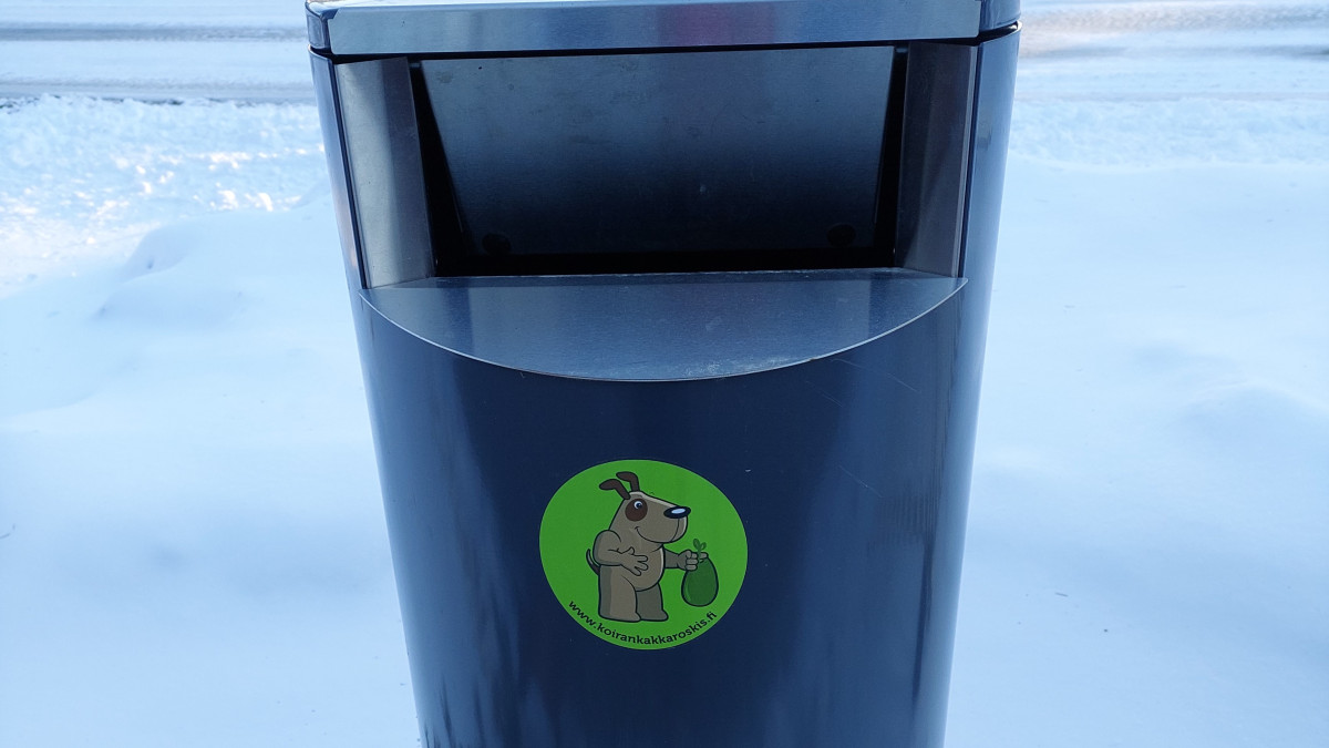 Vihreä ulkoroskis, johon on liimattu koirankakkaroskis-tarra.