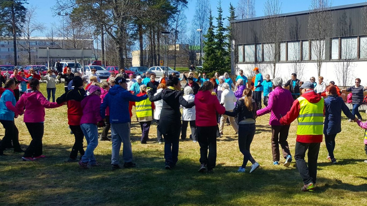 Ihmisiä liikuntatuokiossa urheilutalon pihalla.