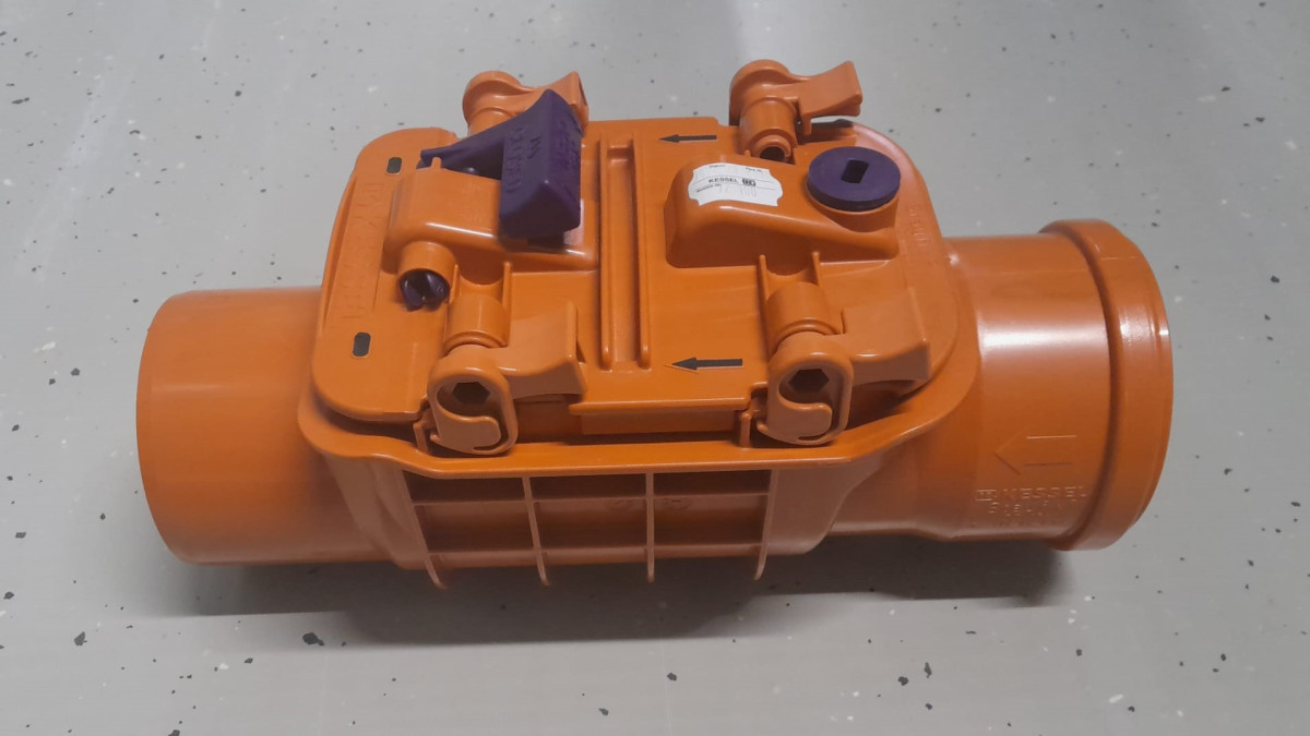 Oranssi padotusventtiili betonilattialla.