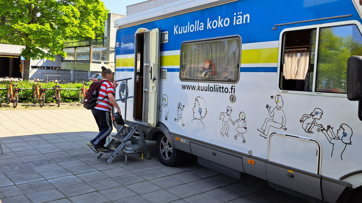 Matkailuauto, johon nousemassa nainen.