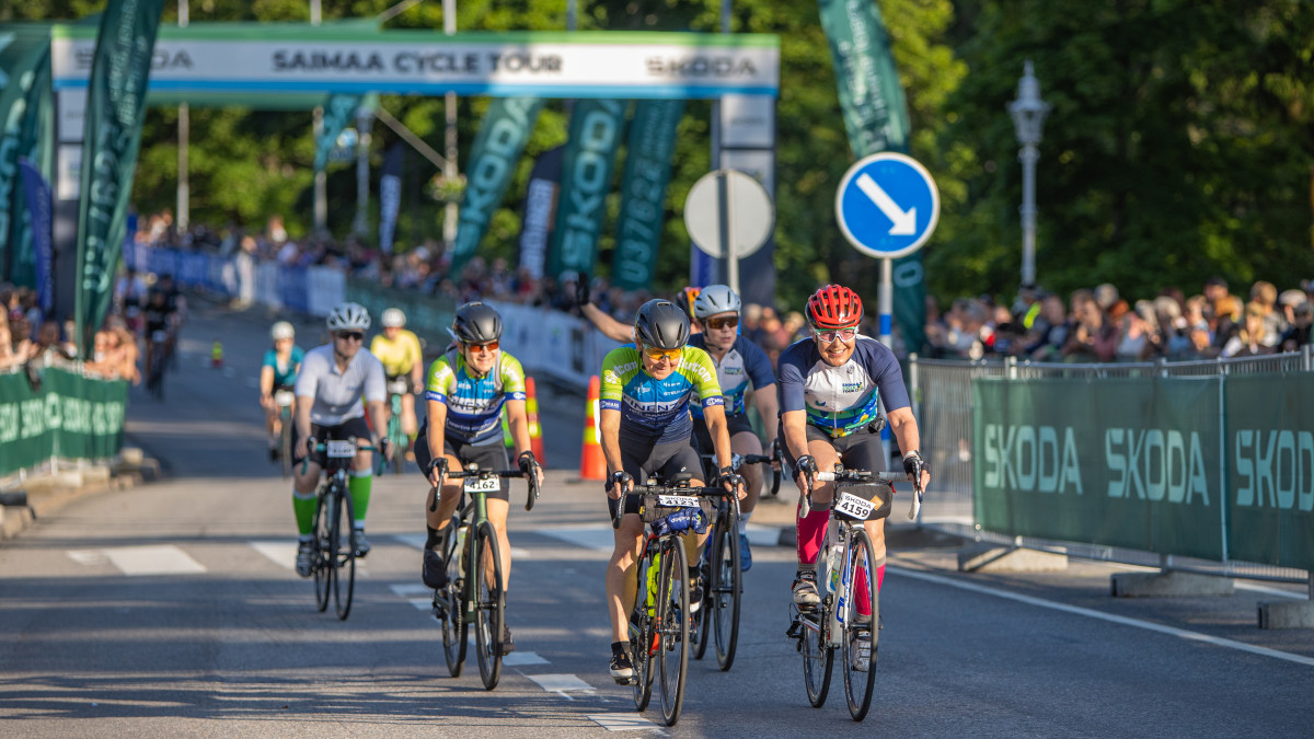 Pyöräilijät Saimaa Cycle Tourin lähtöpaikalla, yleisöä katsomassa.