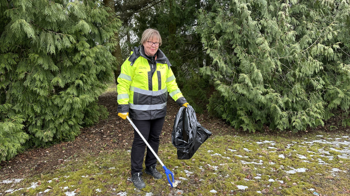 Kaupunginpuutarhuri Erika Luhtanen poimimassa roskia jätesäkkiin.