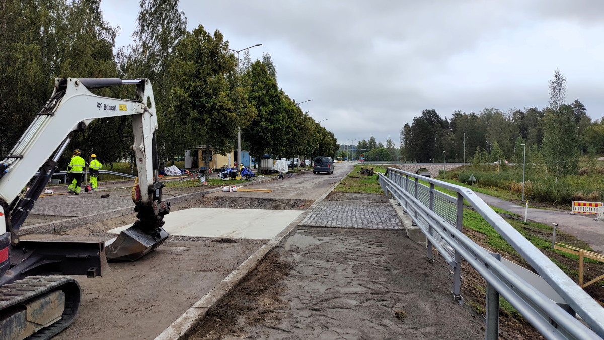 Kaiteen vieressä kadun kunnostus käynnissä, kaivinkone.