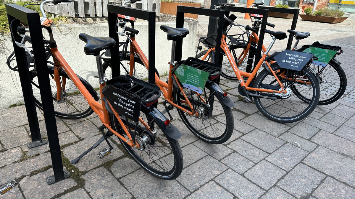 Oranssit kaupunkipyörät telineissä.