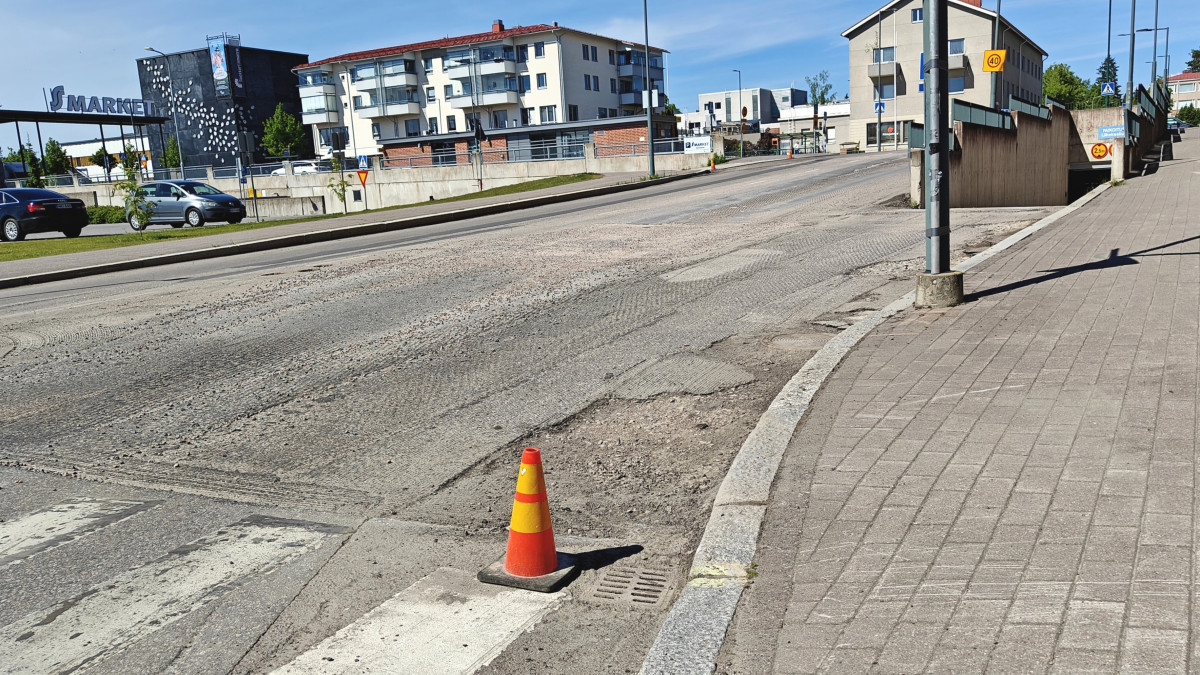 Kadun pinta on jyrsitty, työmaan varoitusmerkki tien reunassa.