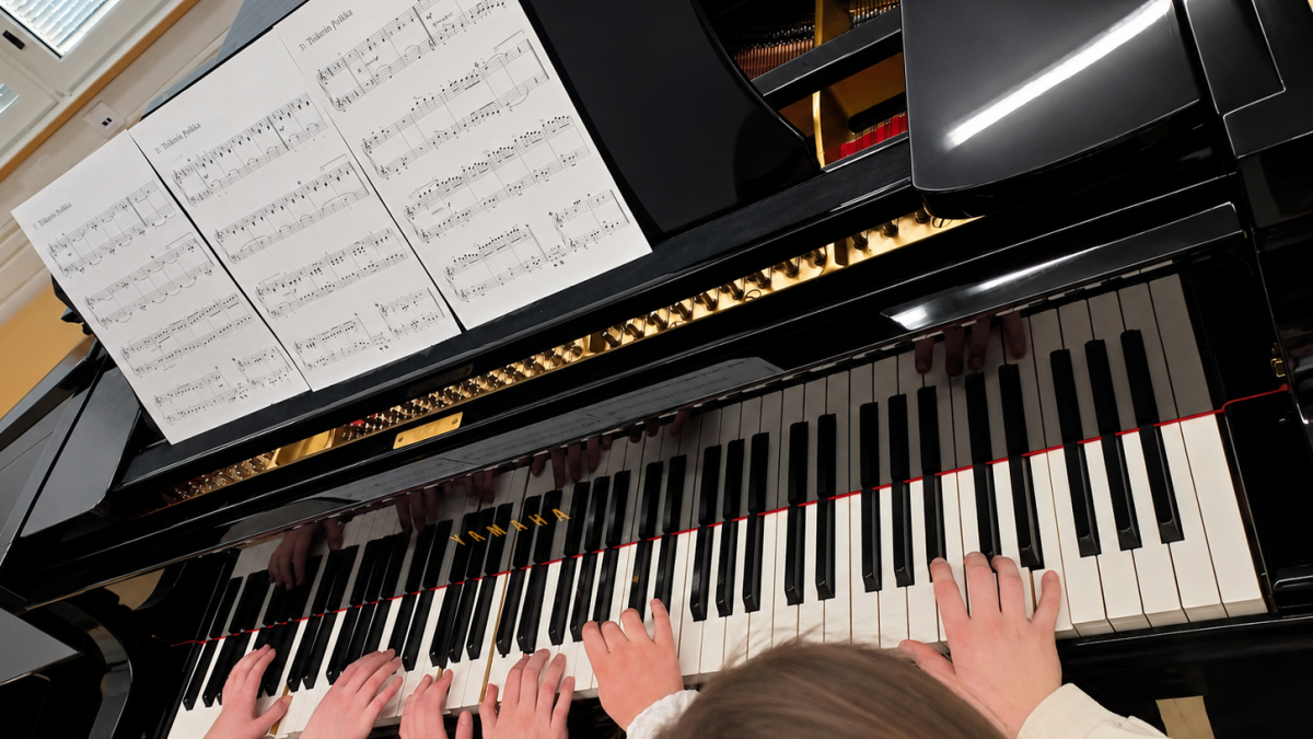 Kolme lasta soittaa pianoa.
