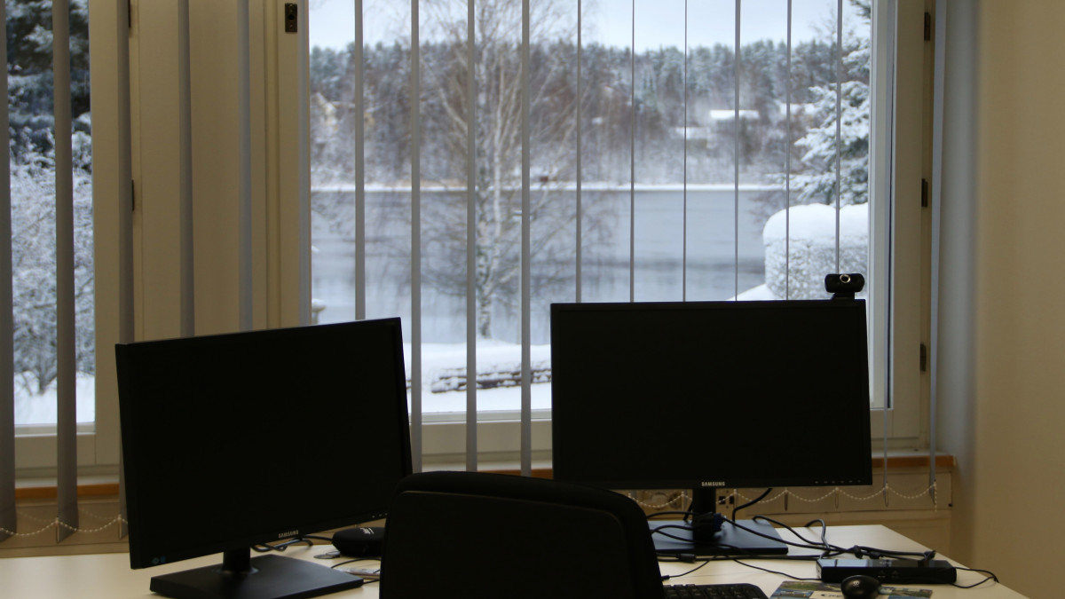 Työpöydän takaa avautuu ikkunasta näkyvä talviselle Vuokselle.