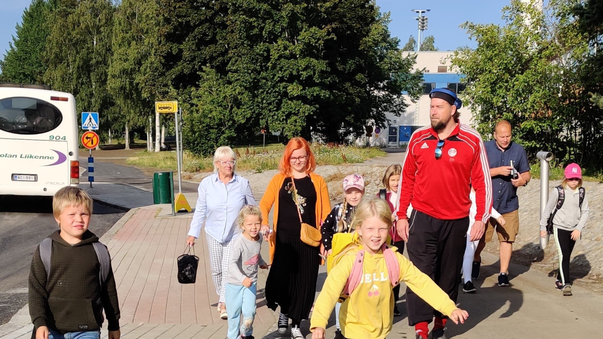 lapsia tulossa kohti kuvaajaa bussilta