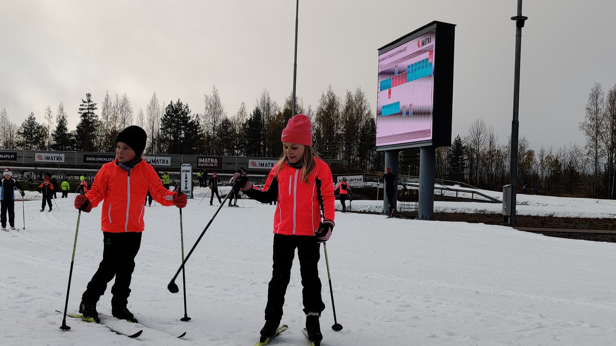 Kaksi tyttöä hiihtämässä ensilumenladulla.