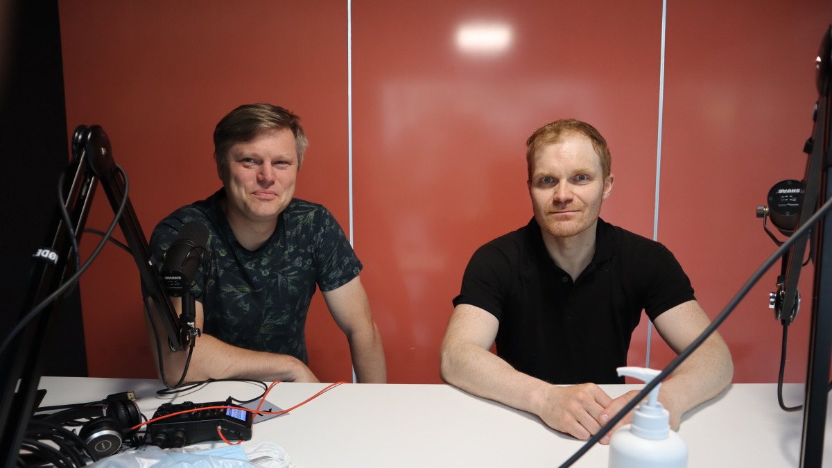 kaksi miestä istumassa studion pöydän ääressä.