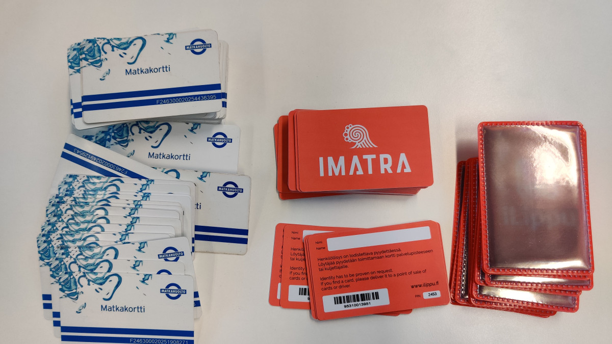Pinoissa vanhoja ja uusia matkakortteja sekä heijastavia koteloita.