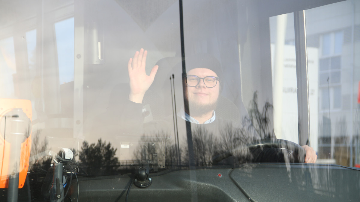 Vilkuttava linja-autokuski ikkunan takaa.