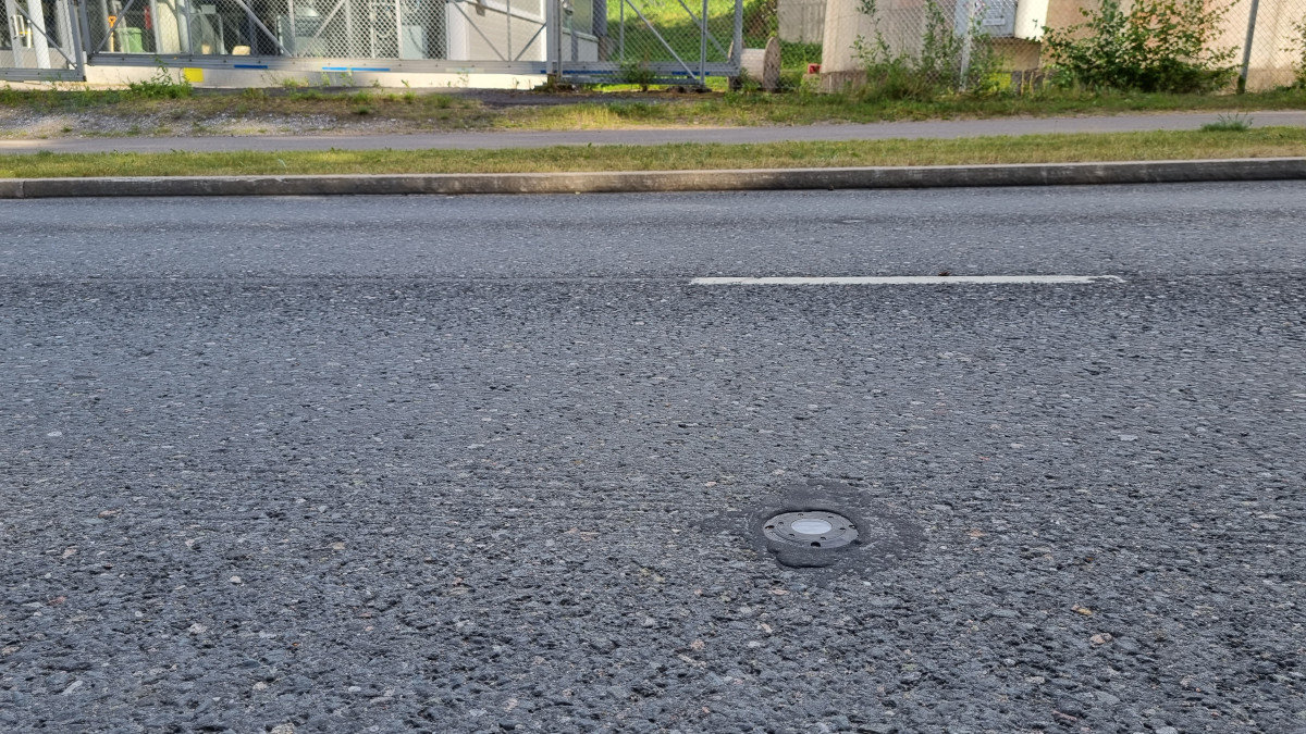 Asfaltoituun katuun upotettu digitaalinen sensori.