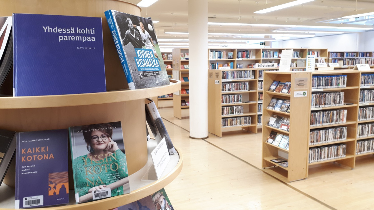 Kirjaston kirjoja ja elokuvia hyllyillä.