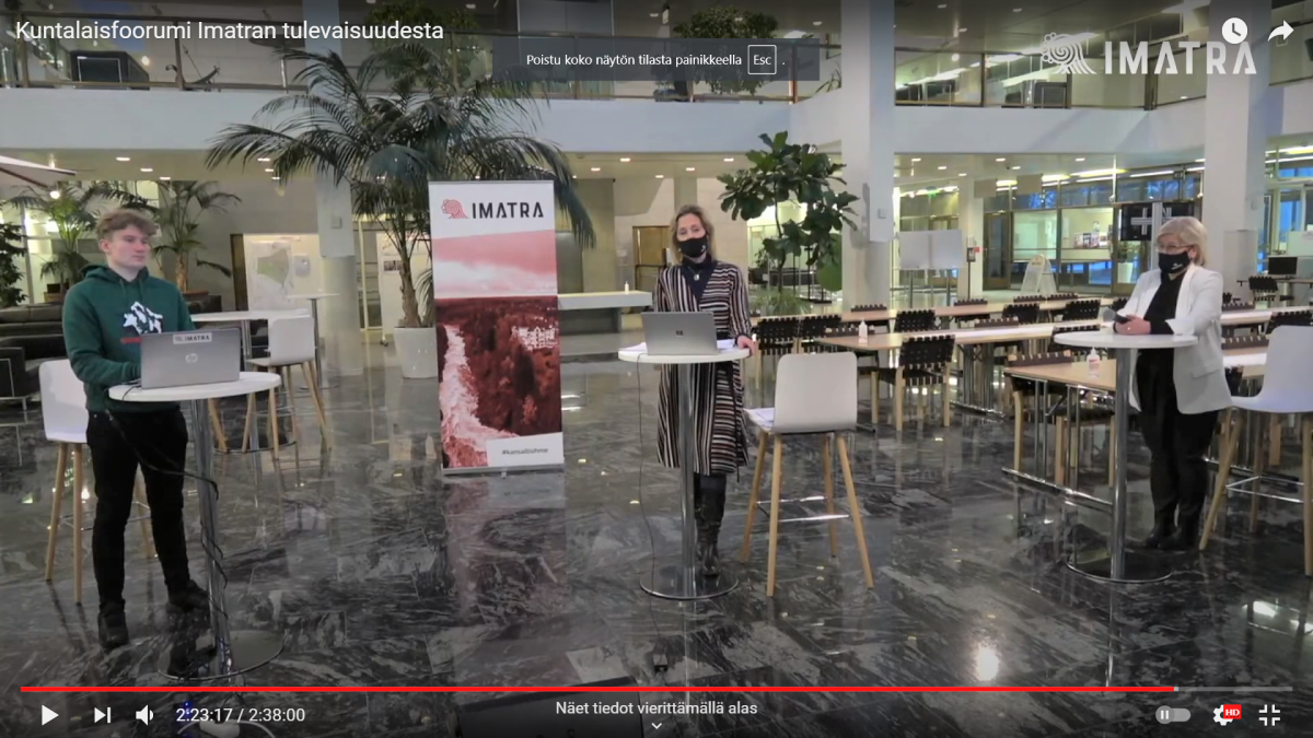 panelistit seisomassa kaupungintalon aulassa.