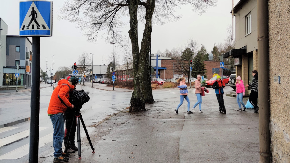 Kuvaaja ja kuvattavat oppilaat kadulla.