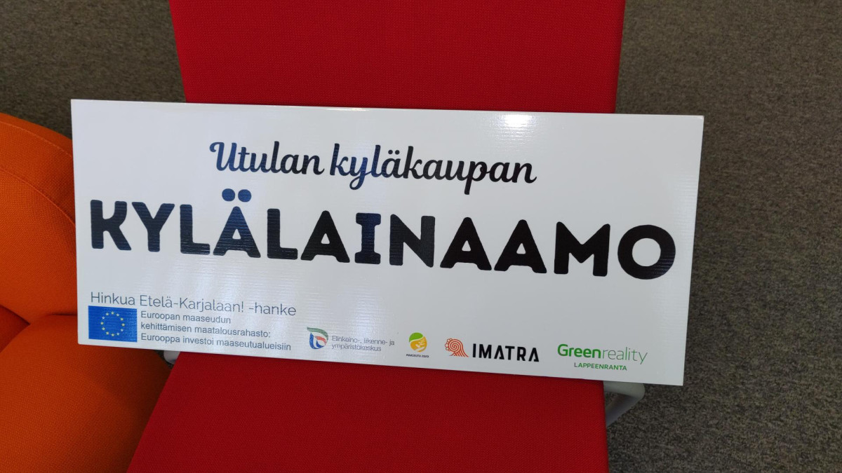 Utulan kylälainaamon kyltti.