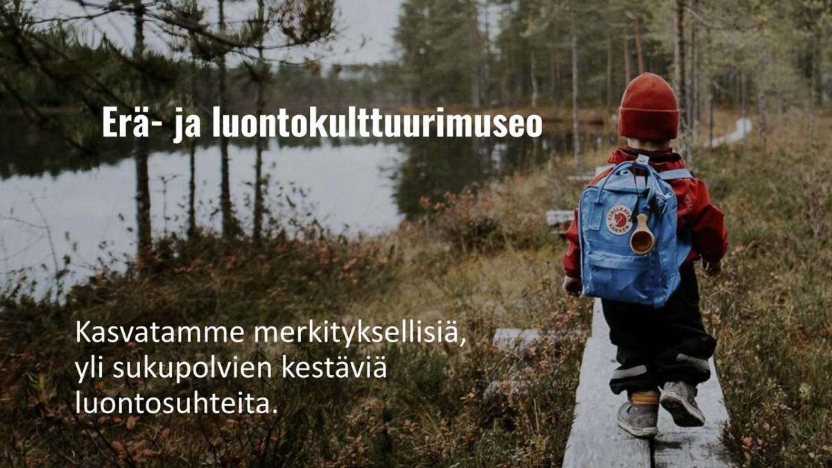 Lapsi reppu selässään kävelee pitkospuilla metsässä, Erä- ja luontokulttuurimuseo.