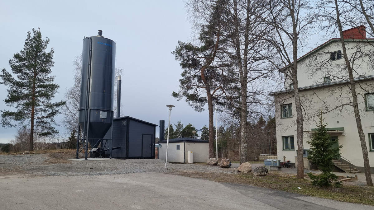 koulurakennus, kontti ja nosturi.