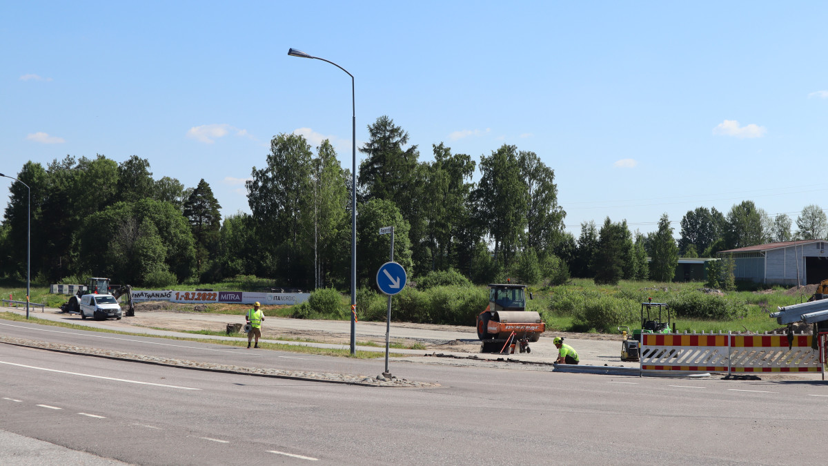 Asfaltointityömaalla kaksi työntekijää.