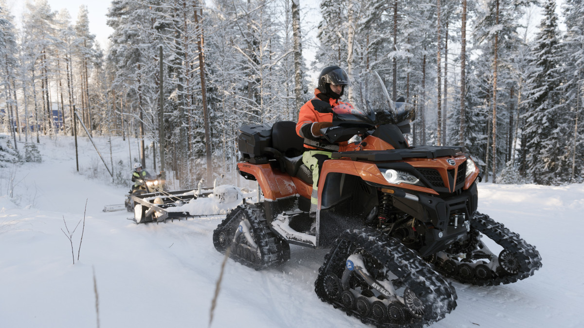 Telaketjumönkijä ladulla, kuski ja perässä ladun tasoitin.