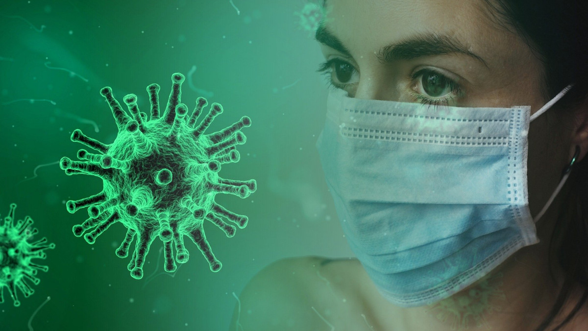 Nainen maskissa, koronavirus kuvitettuna vieressä