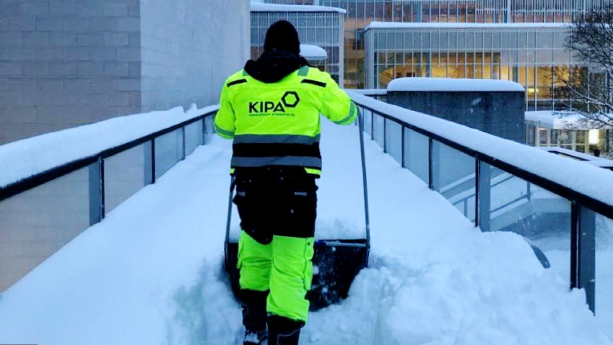 Työmies kolaa lunta.