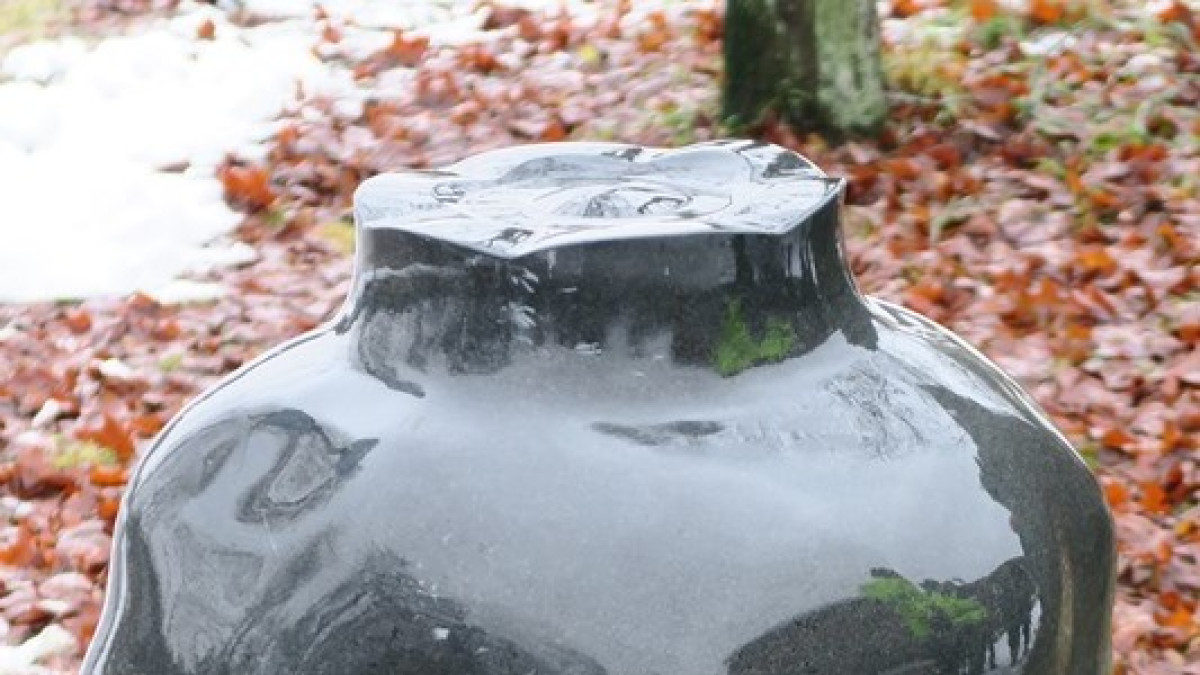 Kivestä hiottu veistos. Ison maljan maljakon muotoinen teos.