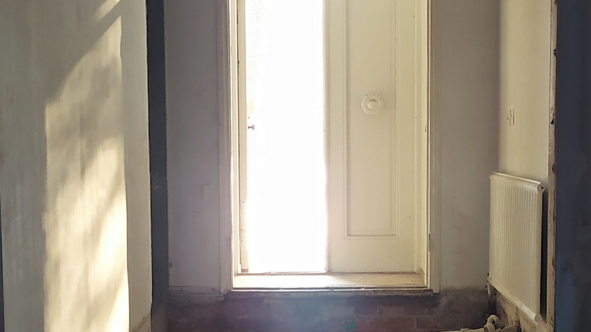 Remontoitavan talon ulko-ovi auki auringonvaloon.