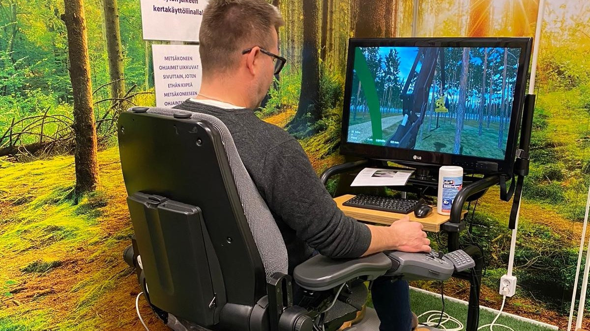 Mikko Airas minikokoisen metsäkoneen ratissa.