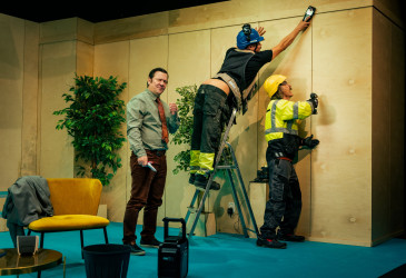 Kolme näyttelijää teatterin lavalla.