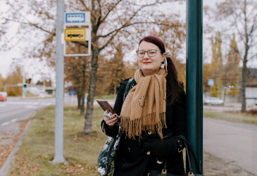 Nainen bussipysäkillä