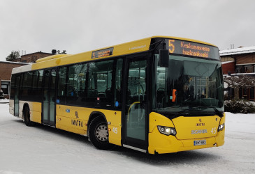 Linja-auto, taustalla tiilirakennus.