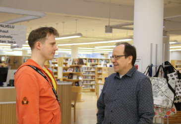 Kaksi miestä kirjastossa.