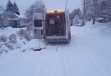 Huoltoauton takaluukku auki talvella, vesiputken kuvaus käynnissä.