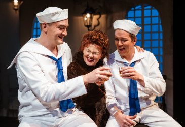 Kolme näyttelijää teatterin lavalla.