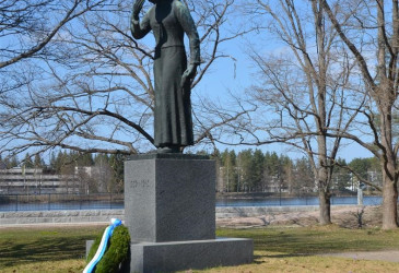 Imatrankosken sankarihautausmaan sankaripatsas ja sen juurella seppele keväällä.
