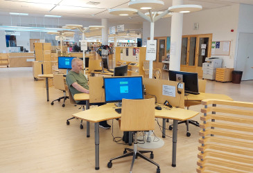 Kirjaston asiakkaiden käytössä olevat tietokonepöydät.