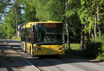 Imatran keltainen linja-auto kapealla kadulla kesällä.