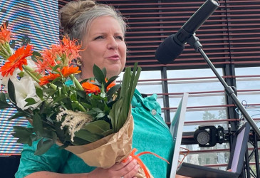 Tiina palkintokukat kädessään pitää kiitospuhetta.