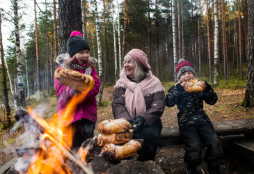 Ihmisiä nuotion äärellä.