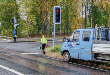 Kiinteistö- ja aluepalvelun työntekijä asentaa aurauskeppejä syksyisessä säässä.