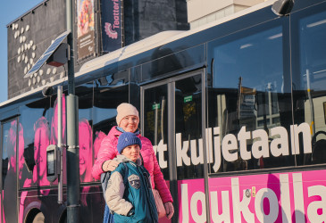 Matkustaijia linja-auton vieressä.