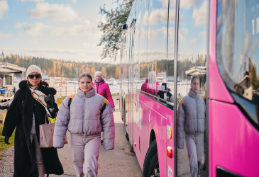 Matkustajia linja-auton vieressä.